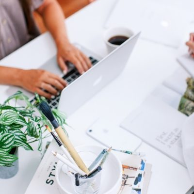 Female business owner typing on a laptop at a work desk